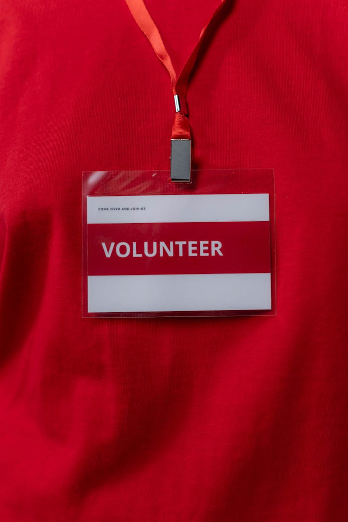 why-choose-us A close-up of a volunteer name tag hanging on a red lanyard, symbolizing community service.