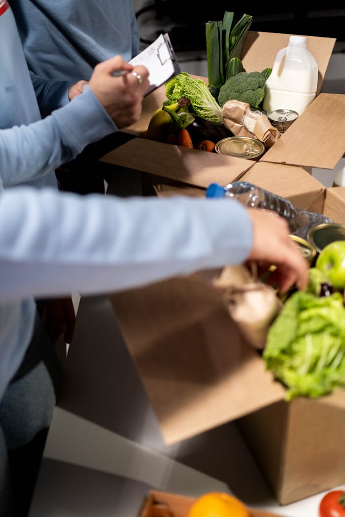 our-services-3 Volunteers organize fresh produce and canned goods for community distribution indoors.